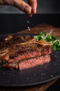 sliced steak on plate with watercress