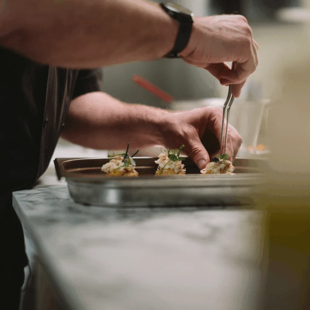 Oxford Guild of Chefs Image, Ben Gibbons plating up food.